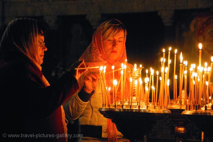 Pictures of Ukraine - women burning candles,  Caves Monastery, Kyiv (Kiev)