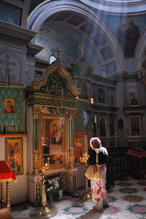 Pictures of Ukraine - Odessa, woman burning a candle in an orthodox church
